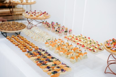 Plateau de petits fours variés disposés sur des présentoirs lors d'un buffet.