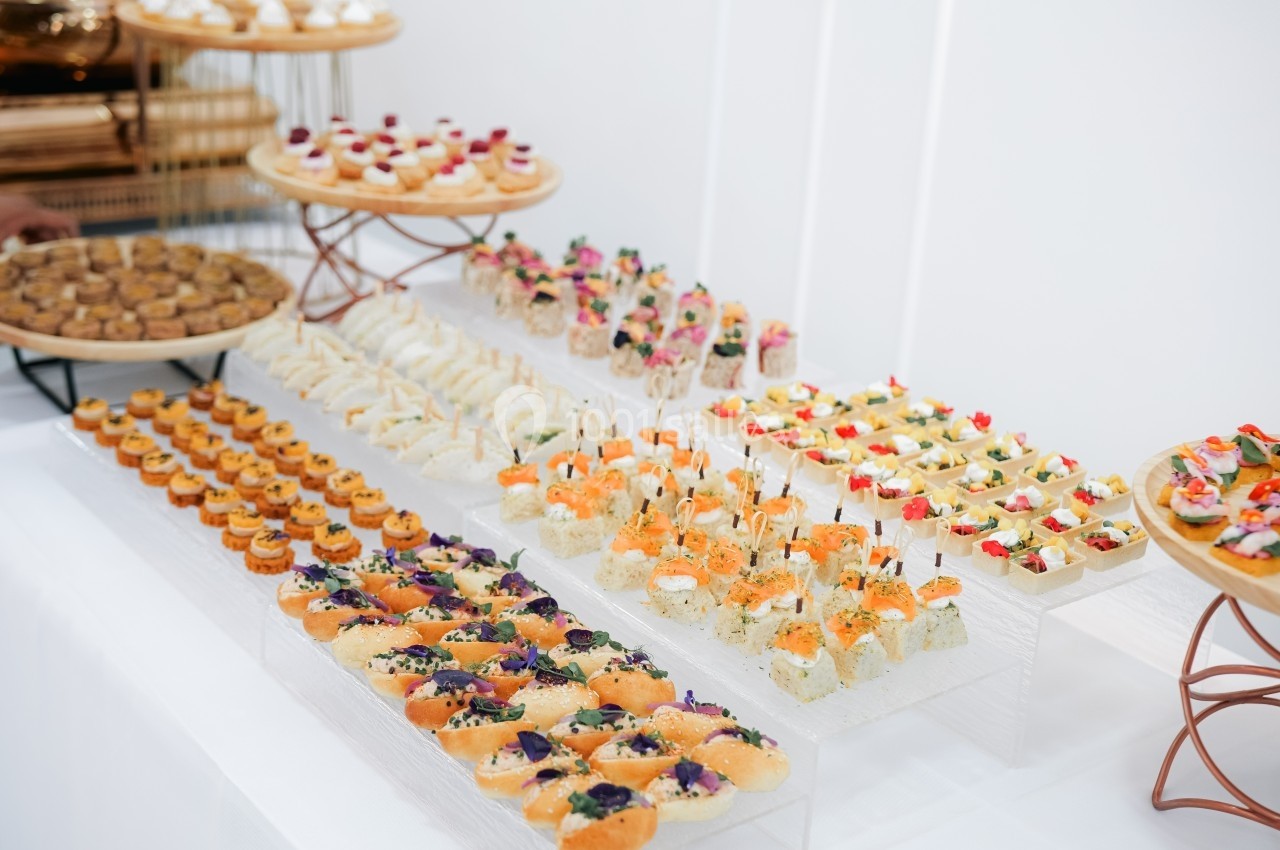 Plateau de petits fours variés disposés sur des présentoirs lors d'un buffet.