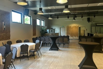 Des invités se servent des amuse-bouches sur des plateaux tenus par une serveuse lors d'un événement convivial.