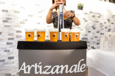 Des invités se servent des amuse-bouches sur des plateaux tenus par une serveuse lors d'un événement convivial.