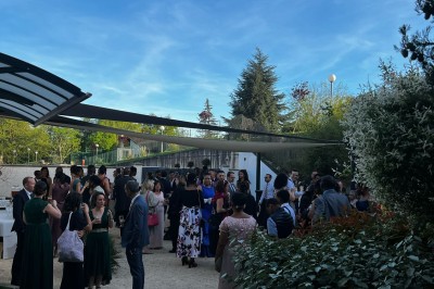 Des invités se servent des amuse-bouches sur des plateaux tenus par une serveuse lors d'un événement convivial.