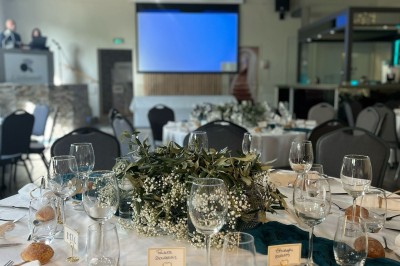 Des invités se servent des amuse-bouches sur des plateaux tenus par une serveuse lors d'un événement convivial.