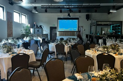 Des invités se servent des amuse-bouches sur des plateaux tenus par une serveuse lors d'un événement convivial.