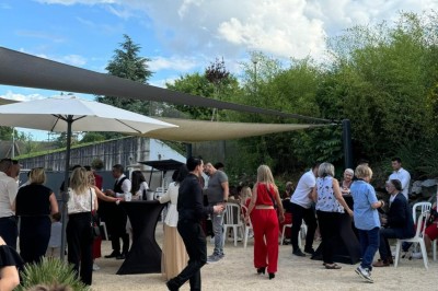 Des invités se servent des amuse-bouches sur des plateaux tenus par une serveuse lors d'un événement convivial.