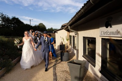 Miniature Location salle Pont-Évêque (Isère) - L'Artizanale #8 Bâtiment avec toit en tuiles, façade blanche, enseigne visible et espace extérieur aménagé avec végétation.