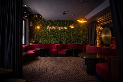 Couloir élégant avec éclairage tamisé, sol brillant et décoration murale en forme de soleil lumineux au fond.