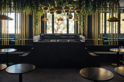 Couloir élégant avec éclairage tamisé, sol brillant et décoration murale en forme de soleil lumineux au fond.