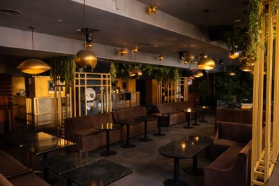 Couloir élégant avec éclairage tamisé, sol brillant et décoration murale en forme de soleil lumineux au fond.