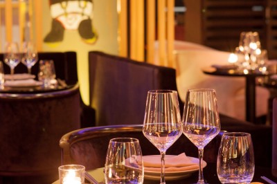 Couloir élégant avec éclairage tamisé, sol brillant et décoration murale en forme de soleil lumineux au fond.