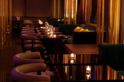 Couloir élégant avec éclairage tamisé, sol brillant et décoration murale en forme de soleil lumineux au fond.