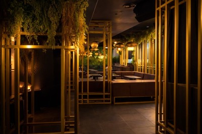 Couloir élégant avec éclairage tamisé, sol brillant et décoration murale en forme de soleil lumineux au fond.