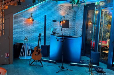 Salle décorée pour une fête avec des tables garnies, une boule disco et des ballons formant le chiffre 40.