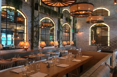 Salle décorée pour une fête avec des tables garnies, une boule disco et des ballons formant le chiffre 40.