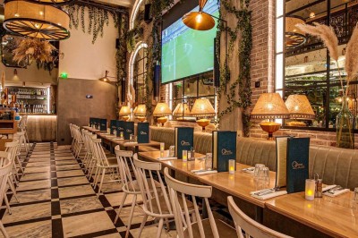 Salle décorée pour une fête avec tables, guirlandes, ballon ’40’ doré et éclairage coloré.