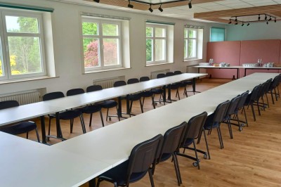 Chambre avec deux lits superposés en bois, fenêtres avec stores bleus et murs blancs.