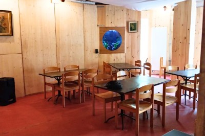 Chambre avec deux lits superposés en bois, fenêtres avec stores bleus et murs blancs.