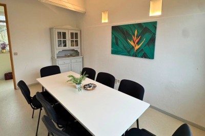 Chambre avec deux lits superposés en bois, fenêtres avec stores bleus et murs blancs.