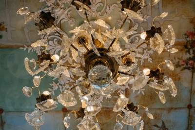 Façade d'un salon de thé parisien avec une devanture noire, une enseigne beige et des chaises en terrasse.