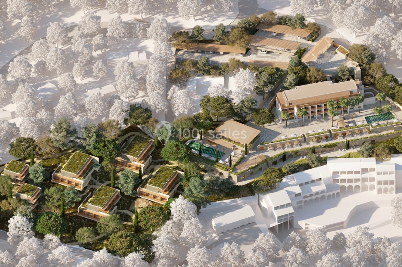 Vue aérienne d'un complexe architectural entouré de végétation, comprenant bâtiments modernes et espaces verts.