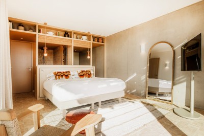 Femme buvant un cocktail rouge avec une paille, en extérieur, cheveux blonds au vent.