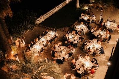 Femme buvant un cocktail rouge avec une paille, en extérieur, cheveux blonds au vent.