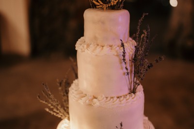Femme buvant un cocktail rouge avec une paille, en extérieur, cheveux blonds au vent.