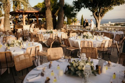 Femme buvant un cocktail rouge avec une paille, en extérieur, cheveux blonds au vent.