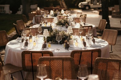 Femme buvant un cocktail rouge avec une paille, en extérieur, cheveux blonds au vent.