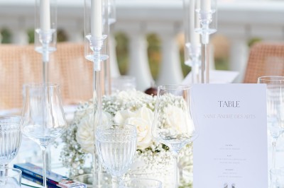 Femme buvant un cocktail rouge avec une paille, en extérieur, cheveux blonds au vent.