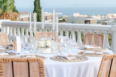 Femme buvant un cocktail rouge avec une paille, en extérieur, cheveux blonds au vent.