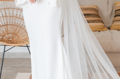 Femme buvant un cocktail rouge avec une paille, en extérieur, cheveux blonds au vent.