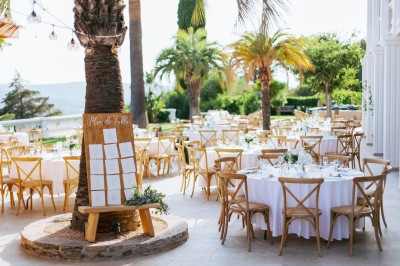 Femme buvant un cocktail rouge avec une paille, en extérieur, cheveux blonds au vent.
