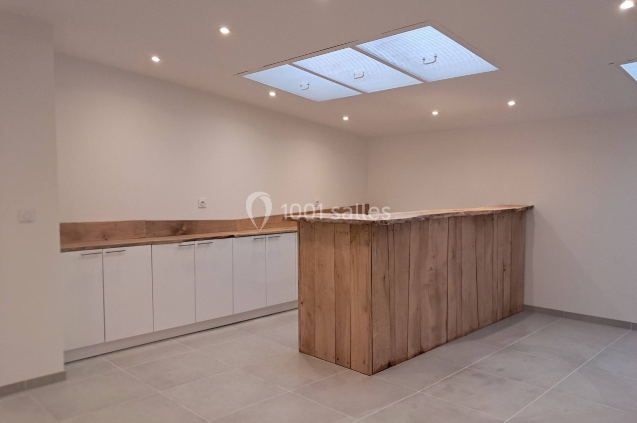 Cuisine moderne avec un îlot central en bois brut, des placards blancs et un éclairage encastré au plafond.