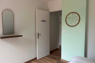 Miniature Location salle Pont-Aven (Finistère) - Domaine de Ker Aven #17 Chambre simple avec deux lits, une table en bois, un miroir mural rond et un rideau vert couvrant une fenêtre.