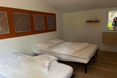 Miniature Location salle Pont-Aven (Finistère) - Domaine de Ker Aven #20 Chambre simple avec deux lits, une table en bois, un miroir mural rond et un rideau vert couvrant une fenêtre.