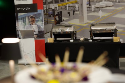 Buffet avec amuse-bouches variés, boissons en carafes et seau à glace sur une table blanche en extérieur.