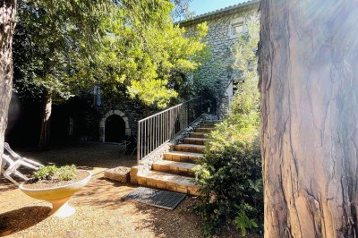 Piscine extérieure avec bassin principal et pataugeoire, entourée de chaises longues et d'arbres.