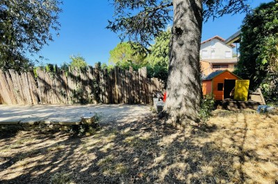 Piscine extérieure avec bassin principal et pataugeoire, entourée de chaises longues et d'arbres.