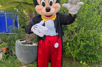Une borne photo en bois avec écran et accessoires, entourée de personnes discutant dans un espace industriel.