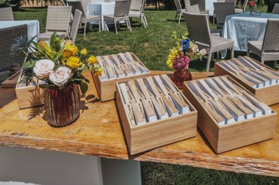 Vue d'une table élégamment dressée avec des verres, des couverts et un bouquet de fleurs colorées au centre.