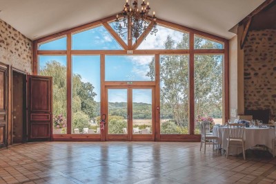 Vue d'une table élégamment dressée avec des verres, des couverts et un bouquet de fleurs colorées au centre.