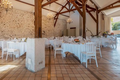 Vue d'une table élégamment dressée avec des verres, des couverts et un bouquet de fleurs colorées au centre.
