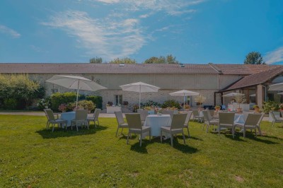 Vue d'une table élégamment dressée avec des verres, des couverts et un bouquet de fleurs colorées au centre.