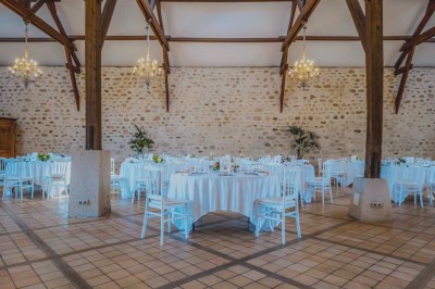 Vue d'une table élégamment dressée avec des verres, des couverts et un bouquet de fleurs colorées au centre.