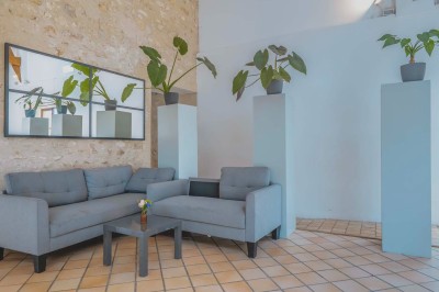 Vue d'une table élégamment dressée avec des verres, des couverts et un bouquet de fleurs colorées au centre.