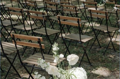Table dressée avec nappes blanches, vaisselle vintage, chandeliers et décorations florales séchées.