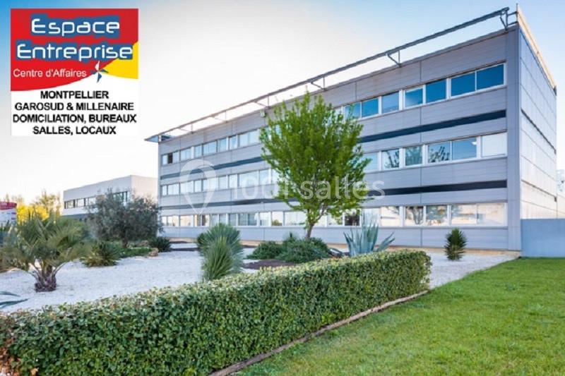 Bâtiment moderne entouré de végétation, avec un panneau indiquant ’Espace Entreprise Centre d'Affaires’ à Montpellier.