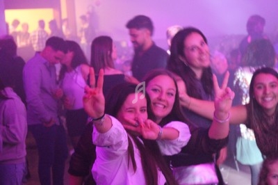 Des personnes souriantes posent joyeusement dans une ambiance festive avec des lumières tamisées.