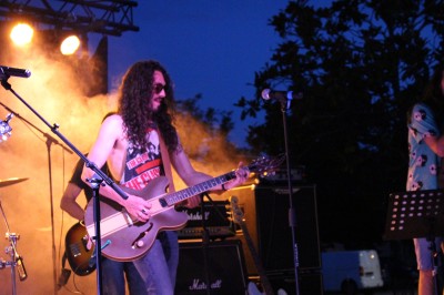 Scène couverte avec une table de mixage, des enceintes et une décoration florale, entourée de barrières de sécurité.
