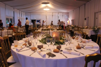 Scène couverte avec une table de mixage, des enceintes et une décoration florale, entourée de barrières de sécurité.